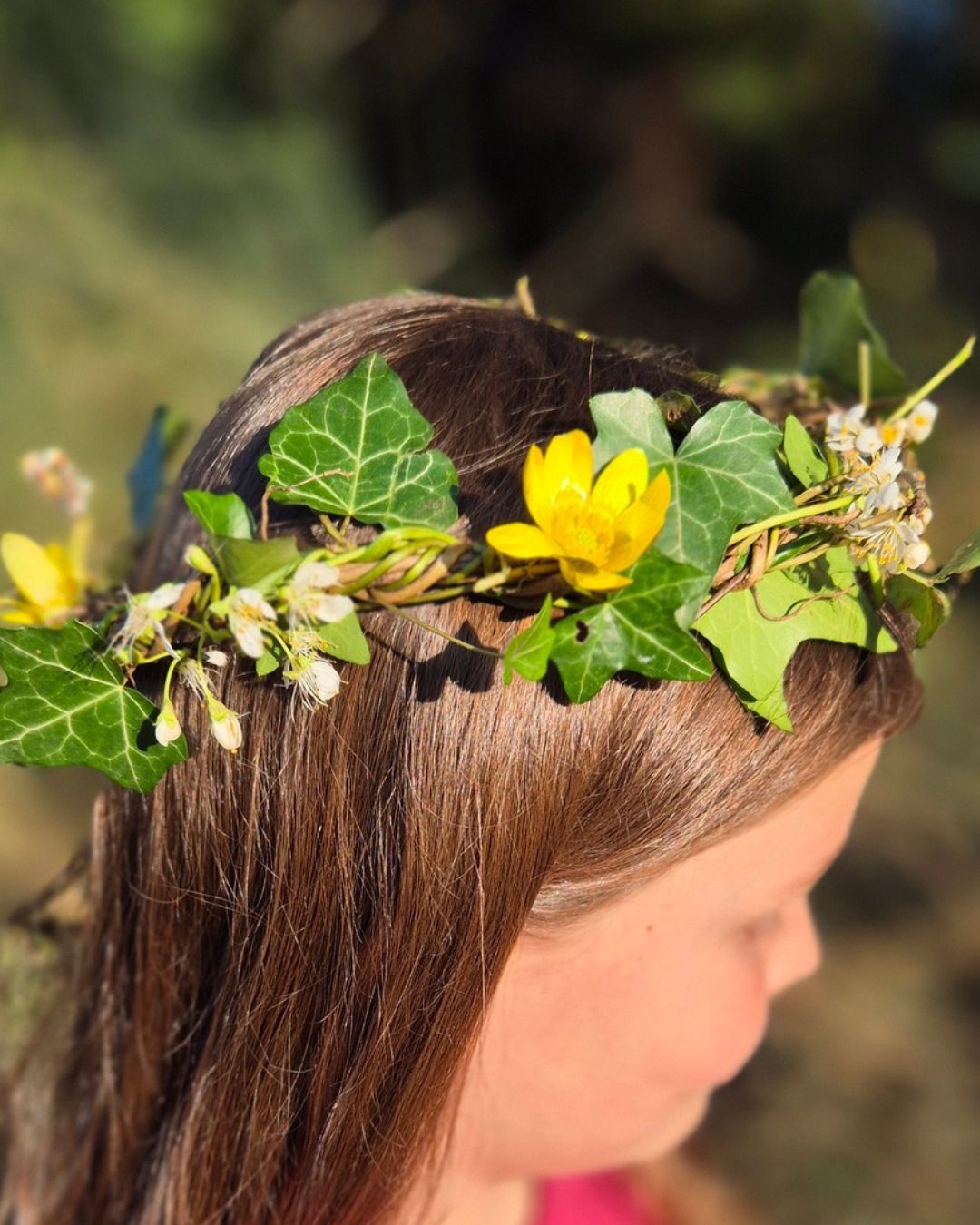 Fille portant une couronne de lierre et de fleurs sauvages cueillies dans la nature
